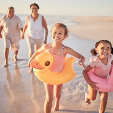 Elderly couple on beach with grandchildren