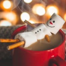 Marshmallow snowman relaxing in tub of hot cocoa