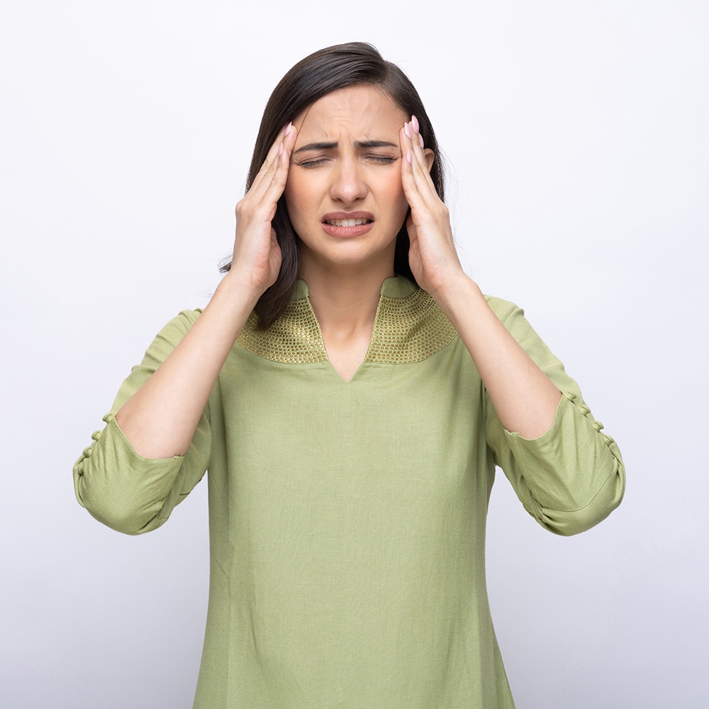 Woman holding head with migrane headache