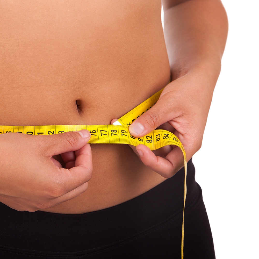 Woman checking waist size uncertain of about diet and gym results